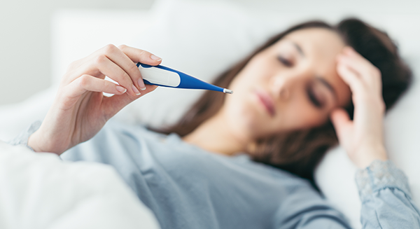 woman with flu and thermometer