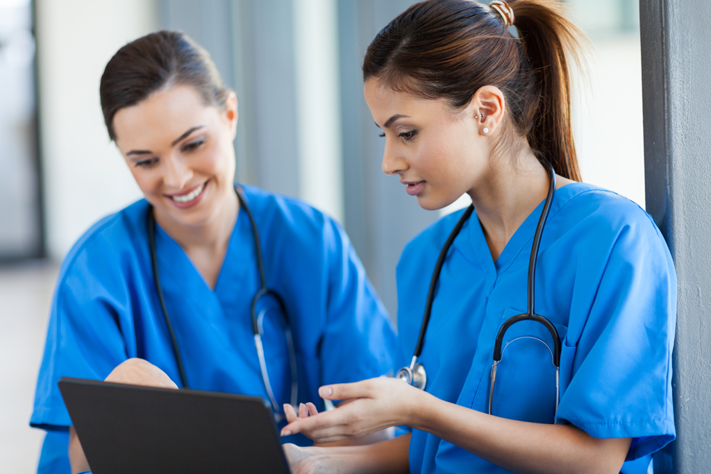 two nurses looking at a laptop