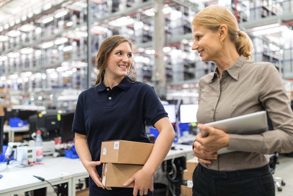 female manager talking with female employee in warehouse