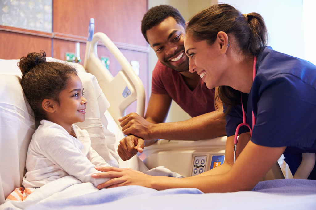 father and nurse tending to daughter in hospital bed