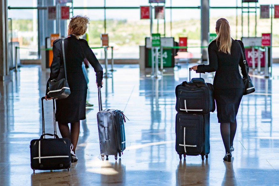 Two flight attendants walking through an airport terminal