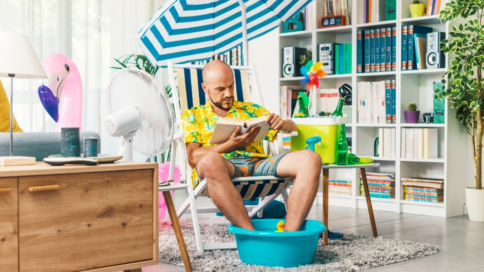Man sitting at home at a make shift beach reading
